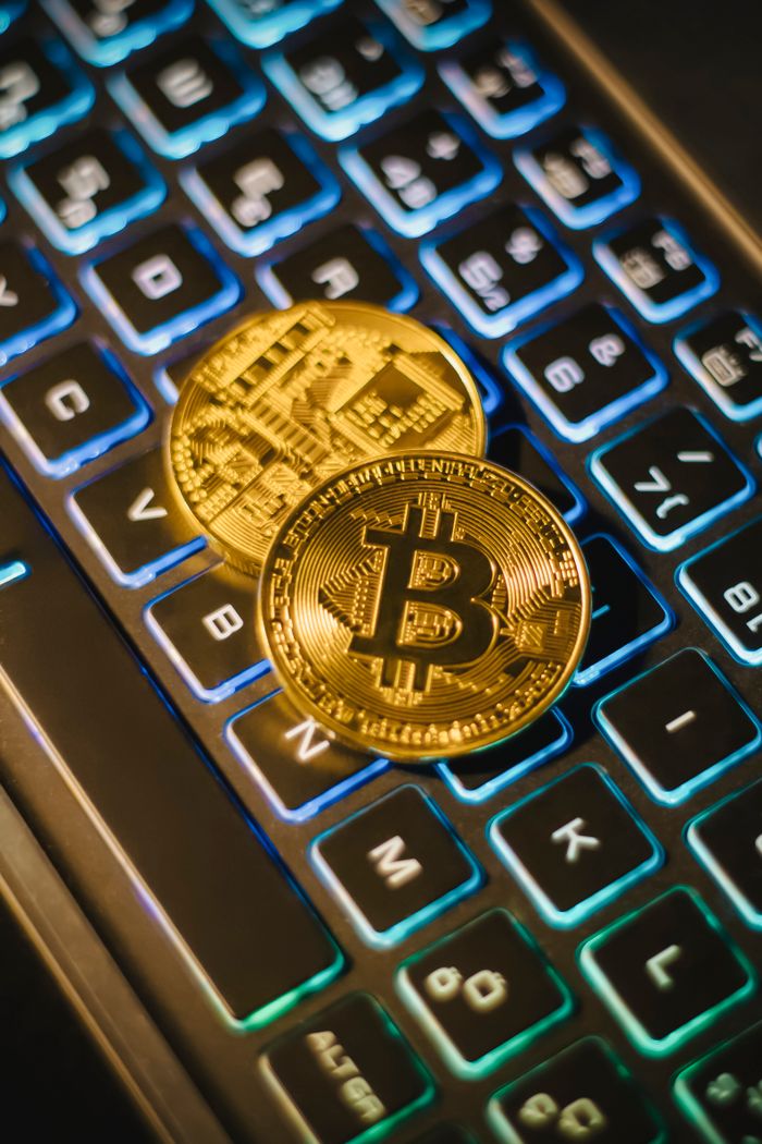 Crafting Captivating Headlines: Your awesome post title goes here Two Bitcoin coins resting on an illuminated keyboard, showing cryptocurrency and digital finance themes.