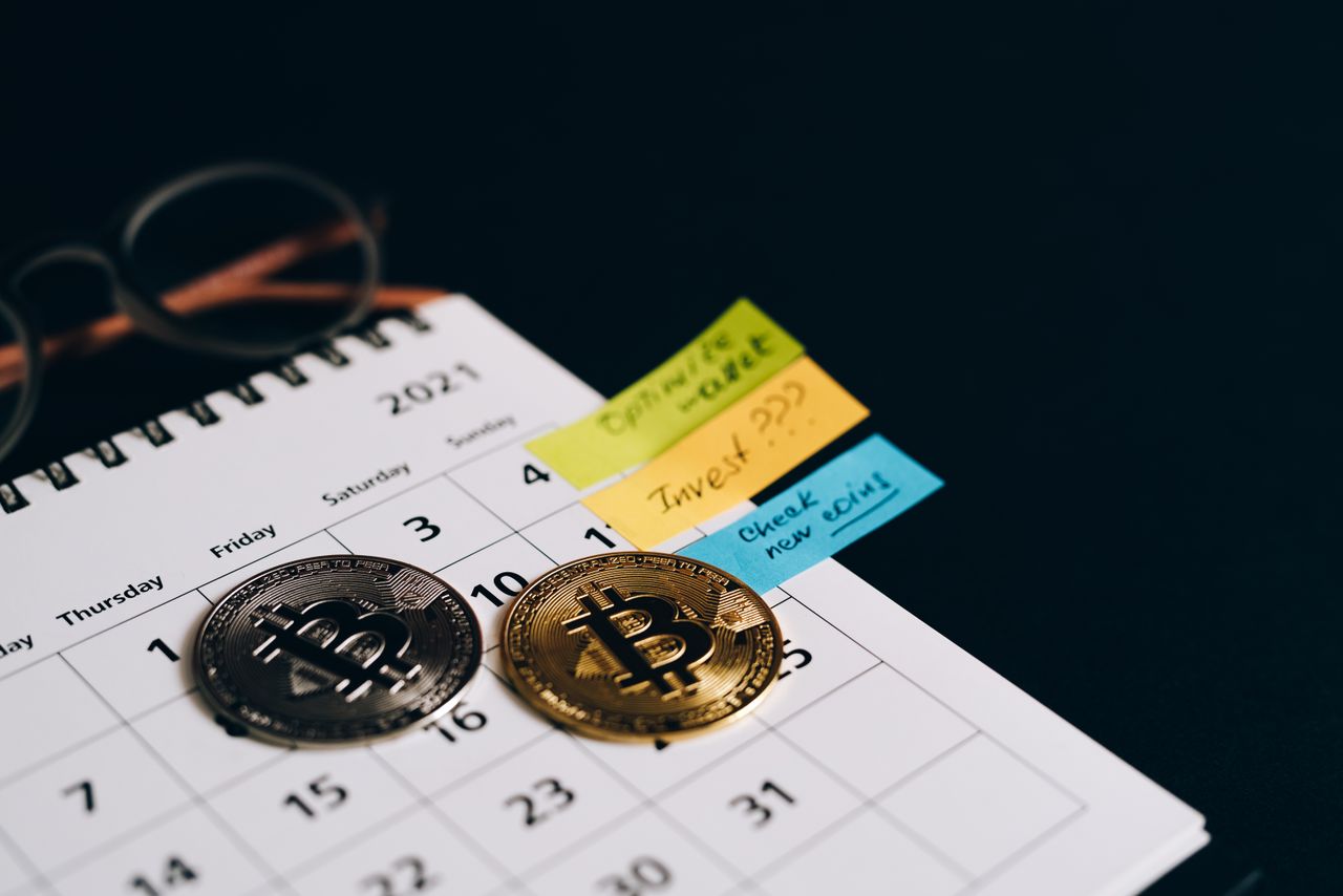 Mastering the First Impression: Your intriguing post title goes here Bitcoin coins placed on a calendar with sticky notes for investment planning.