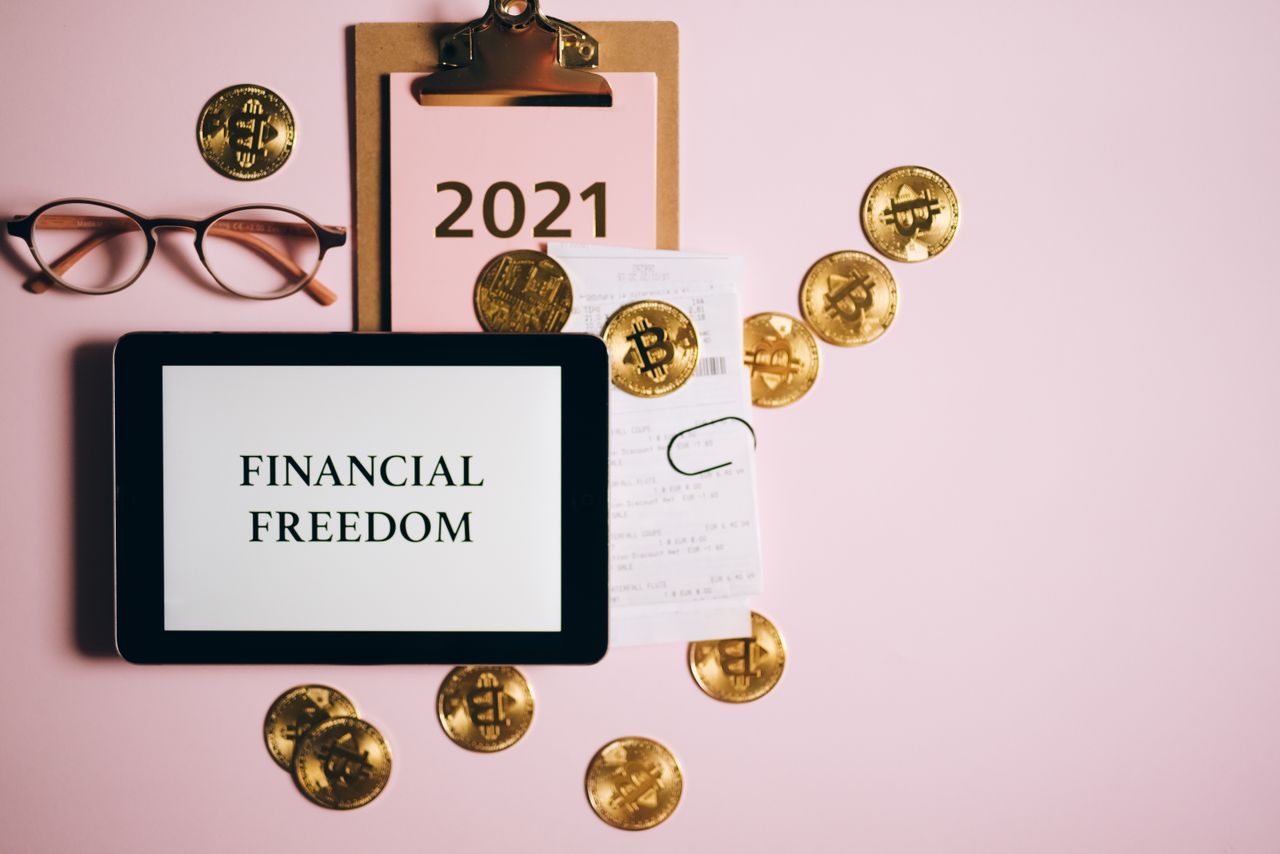 The Art of Drawing Readers In: Your attractive post title goes here Flat lay image of financial freedom concept with bitcoins, tablet, and clipboard on a pink background.